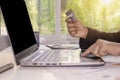 Women with credit cards and mobile phones, including laptops for working on desks.