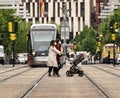 Women crossing in front of the tram with a baby carriage