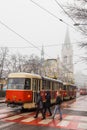 Women cross the road behind a tram