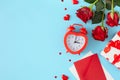 Flat lay photo of red roses, envelope with letter, gift box, hearts and alarm clock Royalty Free Stock Photo