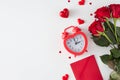 Flat lay photo of red roses, heart shaped alarm clock, envelope, hearts on white background Royalty Free Stock Photo