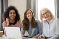 Women different ethnicity and ages looking away laughing at workplace