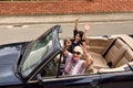 Women of different generations happy in a convertible car