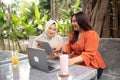 women discuss about work in outdoor cafe