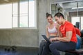 Women are discussing fitness with trainers. Young female talking during workout in gym. Female coach explaining directives with