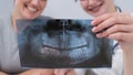 A woman doctor and a patient at the reception are discussing an x-ray of the jaw. Royalty Free Stock Photo