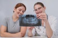 A woman doctor and a patient at the reception are discussing an x-ray of the jaw. Royalty Free Stock Photo