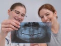 A woman doctor and a patient at the reception are discussing an x-ray of the jaw. Royalty Free Stock Photo