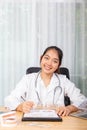 A women doctor is smiling in her office in hospital Royalty Free Stock Photo
