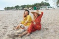 Women And Dog On Beach. Beautiful Girls With Pet On Dog-Friendly Coast. Happy Models Enjoying Summer Vacation