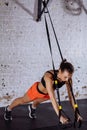 Women doing push ups training arms with trx straps in gym Royalty Free Stock Photo