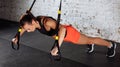 Women doing push ups training arms with trx straps in gym Royalty Free Stock Photo