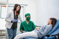 a woman donor lies down during a blood transfusion with two doctors