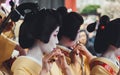 Women dressed as geisha playing music