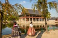 Women dressed in hanbok traditional dresses by the lake at Gyeongbokgung Palace