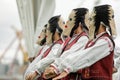 Women dressed in Romanian traditional costumes and with ritual double face masks perform a traditional dance Royalty Free Stock Photo