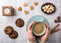 Women drinking coffee with milk and eating cookies top view