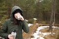 Women drinks beverage from cup and holds termos in other hand. Resting taking a break during hiking