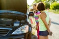 A woman driver with a child on a country road, near a broken car Royalty Free Stock Photo