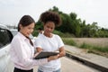 Women drivers Talk to Insurance Agent for examining damaged car and customer checks on the report claim form after an accident.