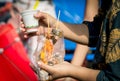 Women are eating roasted squid with seafood sauce in clear plastic bag along with ice cream