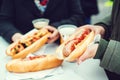 Women eating sausage at street food festival. Czech market in Prague. Street food at winter time in European town. Travelling and