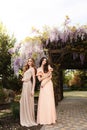 Women in elegant dresses, posing in blossom spring garden Royalty Free Stock Photo