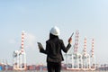 The women engineer holding radio and working with container Cargo freight ship in shipyard at dusk for Logistic Import Export back Royalty Free Stock Photo