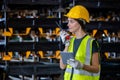 women engineer holding walkie talkie and tablet quality control standing at machine of factory warehouse. professional engineering