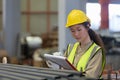 Women engineer take notes on paperwork quality control standing at machine.