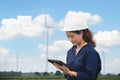 Women engineer using tablet for working on site at wind turbine farm