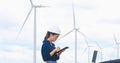 Women engineer using tablet for working on site at wind turbine farm Royalty Free Stock Photo