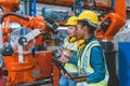 Women engineer worker working team training together at work in modern advanced robot welding machine factory Royalty Free Stock Photo