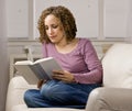 Women enjoying reading a book in livingroom