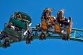 Women enjoying turns, with hair in the wind, in Cobra`s Curse Roller Coaster at Bush Gardens Tampa Bay _