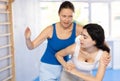 Women exercising armlock grip while sparring in sport gym