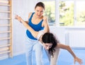 Women exercising armlock grip while sparring in sport gym