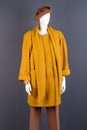 Women fashionable yellow topcoat on mannequin.