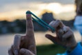 Women Finger with green rubber band targeting with a sunset behind