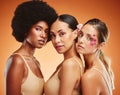 Women, flowers and beauty in makeup, diversity and models on orange studio background. Cosmetic, skincare and happy