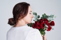 After women, flowers are the most divine creations. Studio shot of a young woman smelling a bunch of roses.