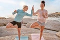 Women friends, beach yoga and happy in morning with stretching pose for health, wellness and helping hand. Black woman