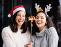 Women friends, Christmas and sparkle stick with smile, home and celebration of festive holiday. Girl, woman and Royalty Free Stock Photo