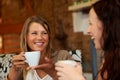 Women friends, happy and talk in cafe for reunion, thinking and smile with drink together for speaking. Girl, coffee