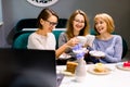 Women friends looking at cakes, three girl friends drinking coffee in the cafe and eating desserts, women during lunch Royalty Free Stock Photo