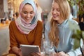 Women. Friends Meeting In Cafe. Smiling Girls Looking At Tablet Screen. Royalty Free Stock Photo