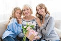 Women generation. Granny with presents, mom and daughter hugging grandmother Royalty Free Stock Photo