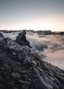 Women girl with backpack enjoying sunset on mountain peak of foggy mountain. Hiker looking sunlight in trip in Austria.Travel