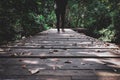 Women or girl walking alone on wooden track in forest