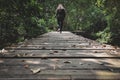 Women or girl walking alone on wooden track in forest